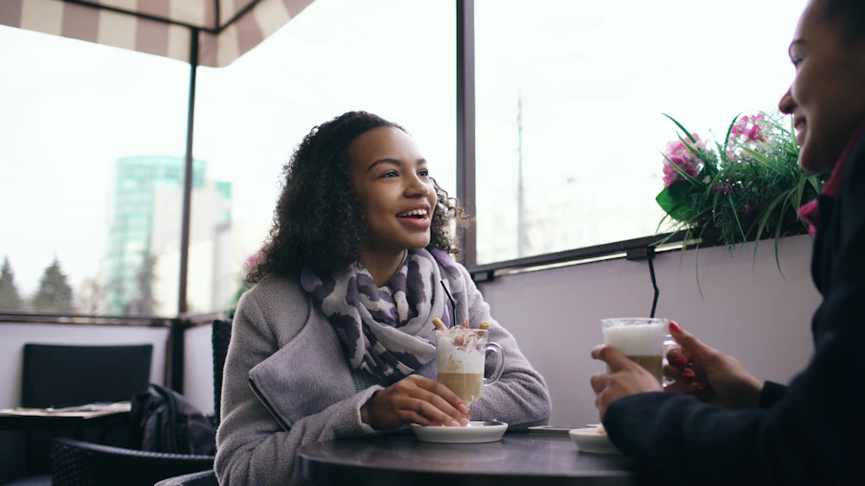 Friends smiling and catching up over coffee